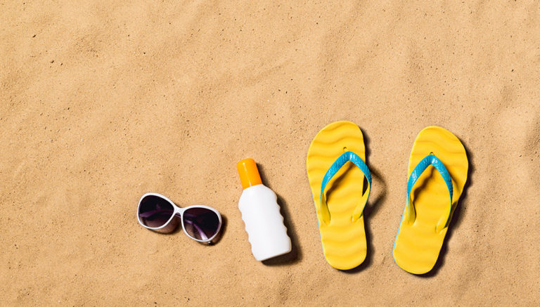 Sand, sunglasses, sunscreen, and flip flops